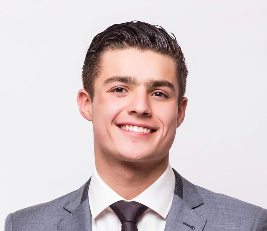 Happy business man wearing grey suit standing isolated on white background